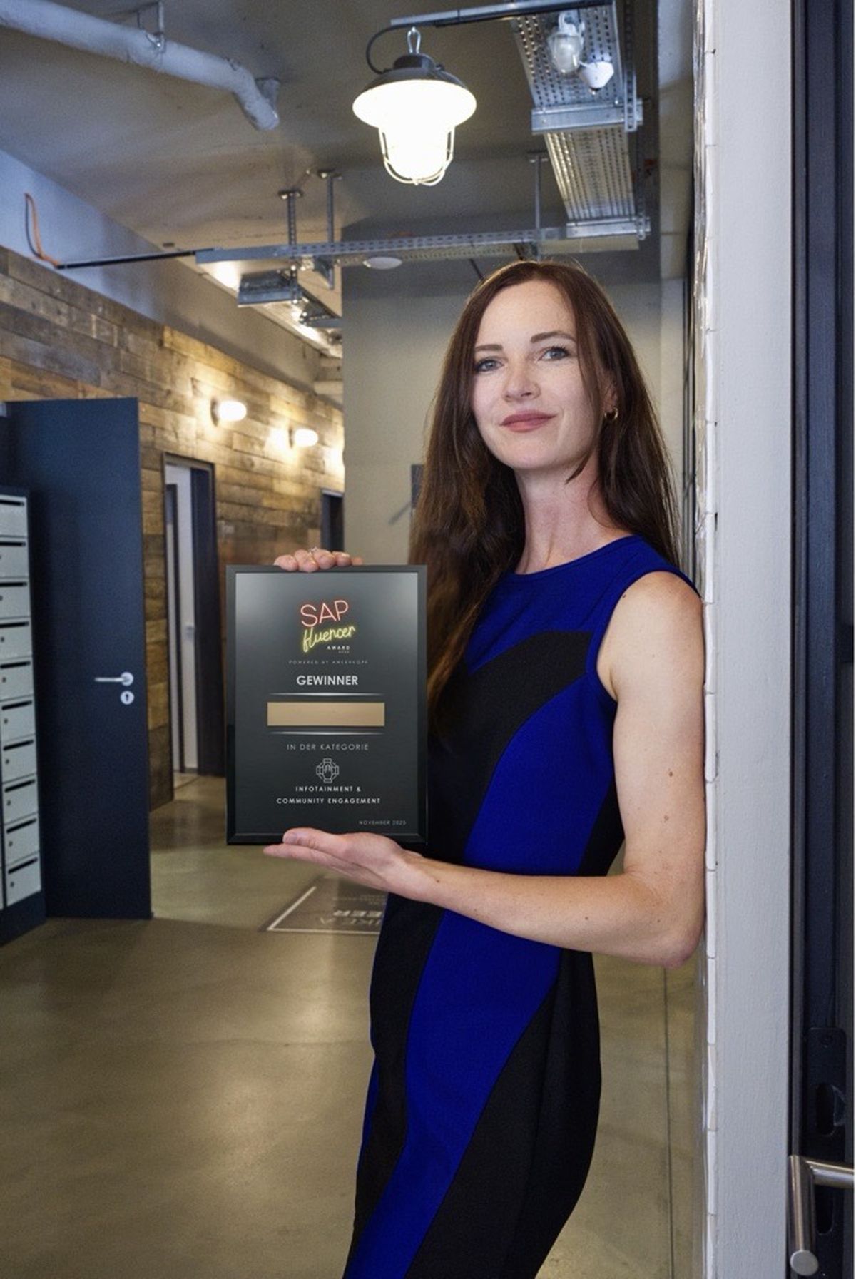 Sarah Niesel hält eine Award-Urkunde der Kategorie Infotainment und Community Engagement